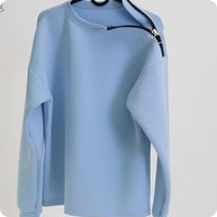 pale blue jumper with zip at collar hanging on a clothing rail